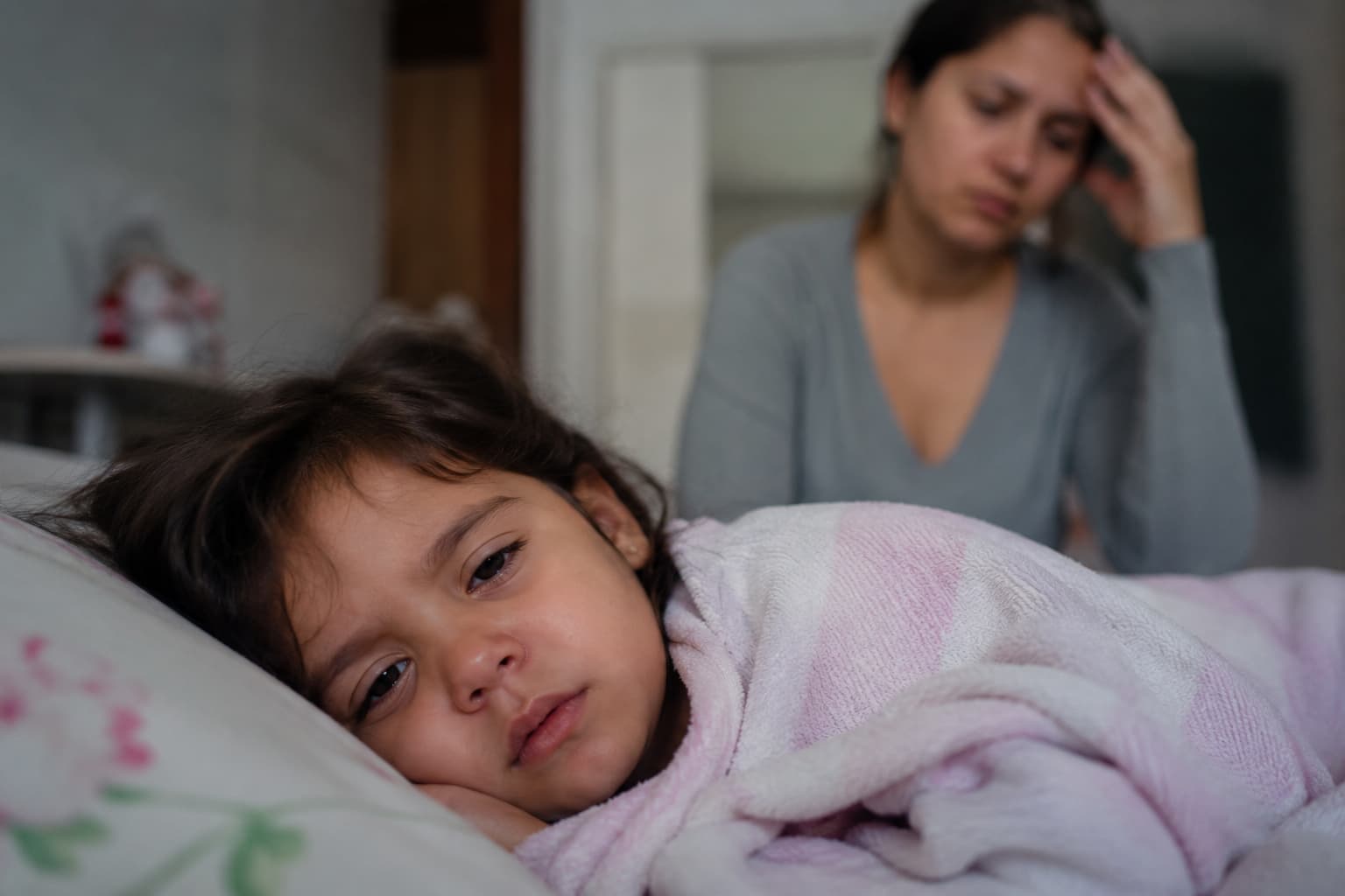 Mãe exausta cuidando da filha doente